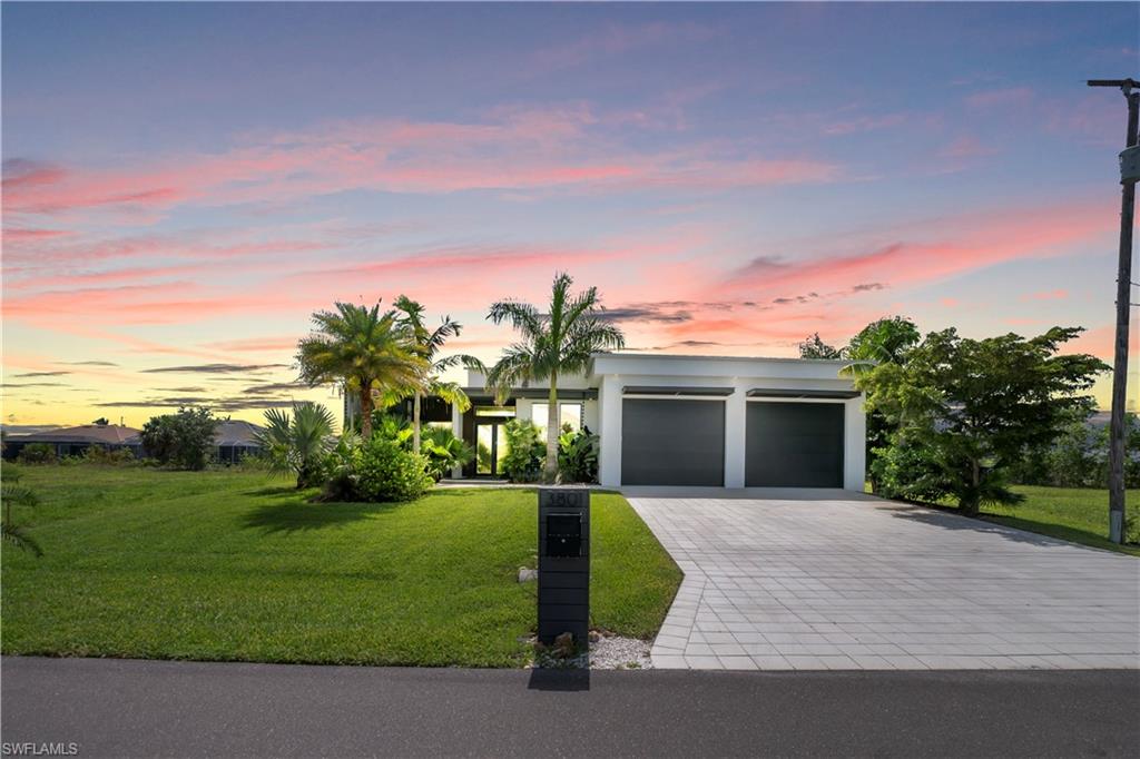 Contemporary single-story residence featuring a flat roofline and integrated two-car garage with dark doors