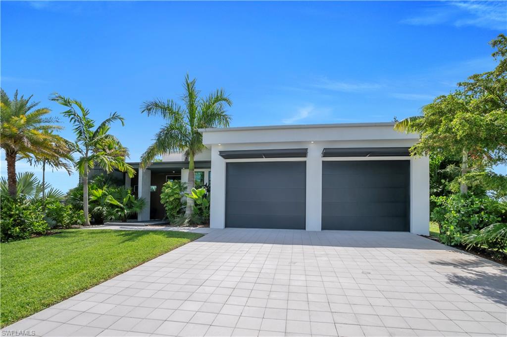 Modern single-story residence with a smooth stucco exterior and a flat roofline