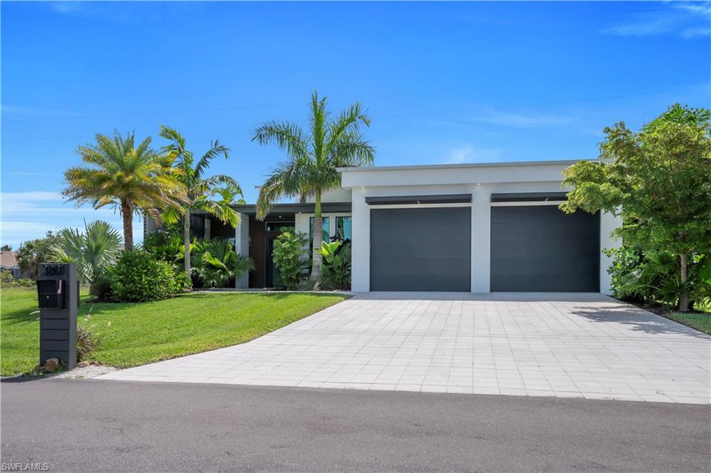 Modern single-story residence featuring a flat roofline and a two-car garage with dark gray doors