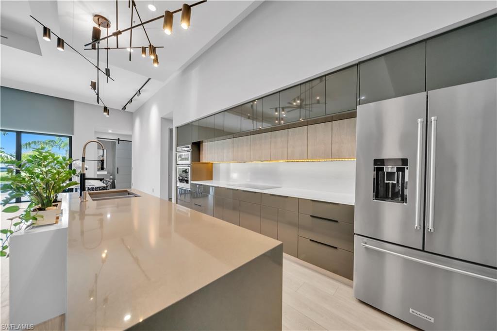 Modern kitchen featuring an expansive island with an integrated sink and gooseneck faucet