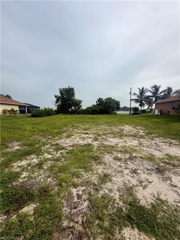 Expansive open lot featuring partial grass coverage and sandy ground