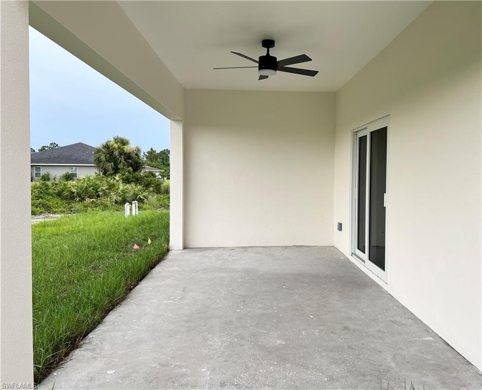 Covered patio featuring a ceiling fan, concrete flooring, and direct access through sliding glass doors