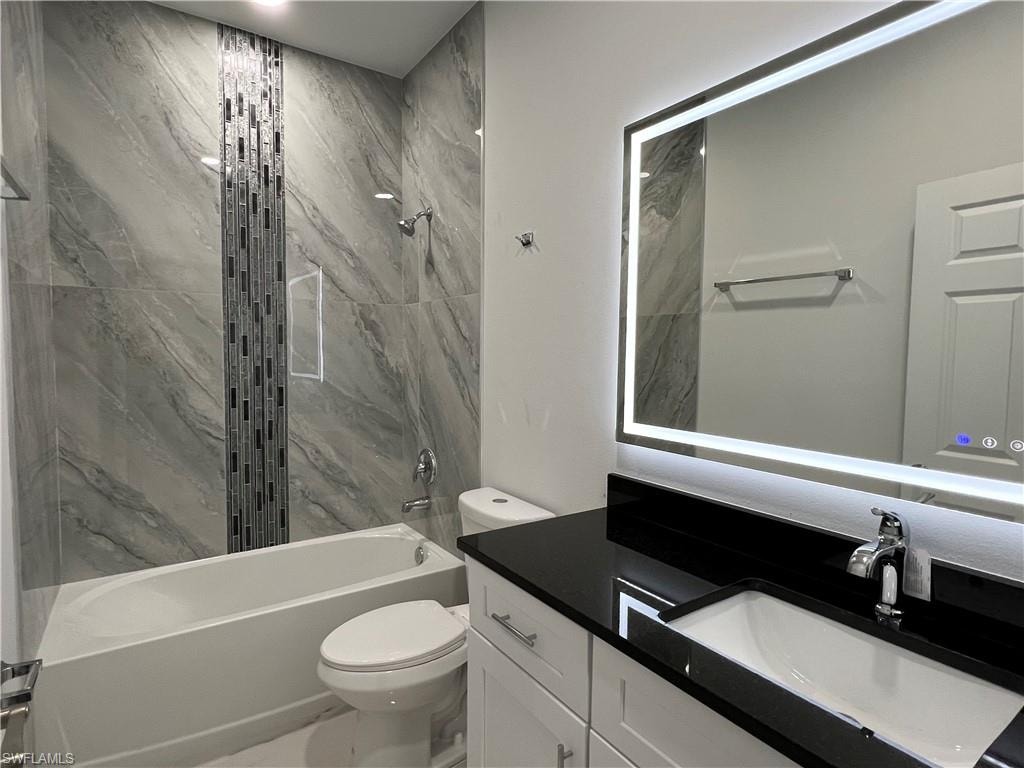 Modern bathroom featuring a lit vanity mirror and a single-basin sink with a chrome faucet