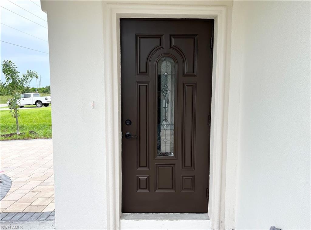 Paneled front door featuring decorative glass inserts, a dark bronze finish, and a coordinating dark bronze handle set