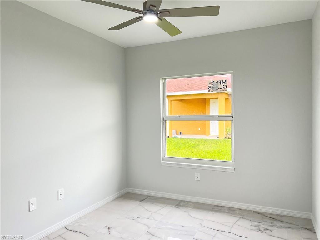Interior room featuring light gray walls, white baseboards, and patterned tile flooring