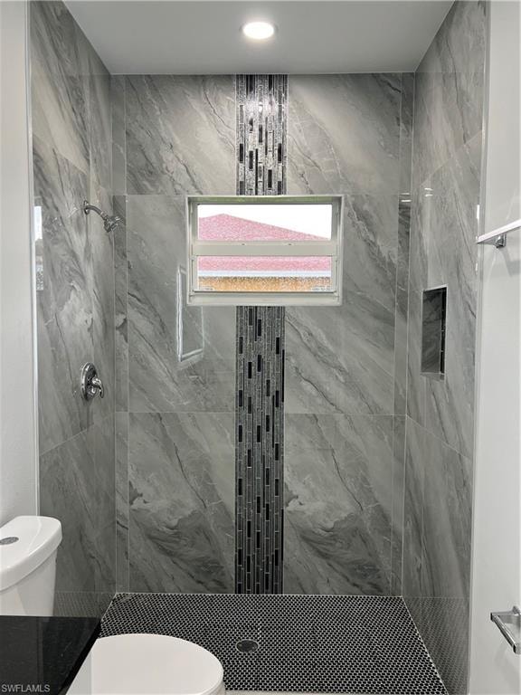 Shower stall with large format gray veined tile walls, linear mosaic accent strip, and a hinged window
