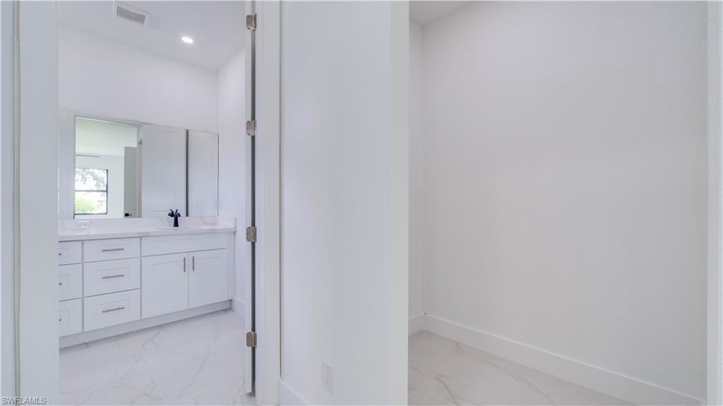 A view leading to the en-suite from the primary suite hallway. One of the two walk-in closets is on the right.