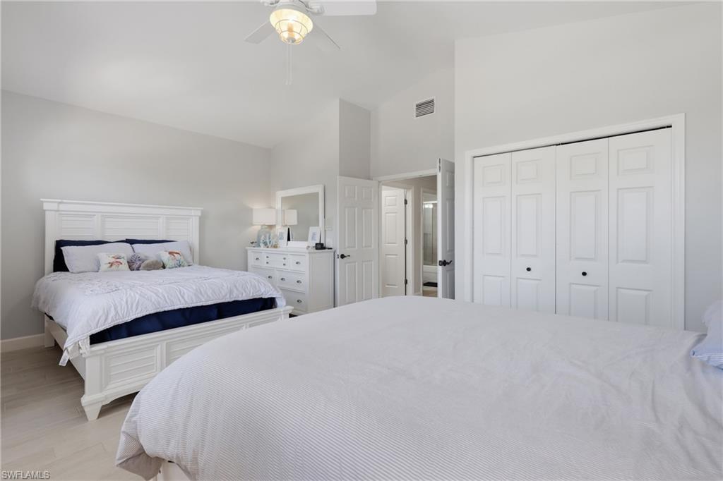 Spacious room featuring vaulted ceilings, a ceiling fan with integrated lighting, and light-toned flooring