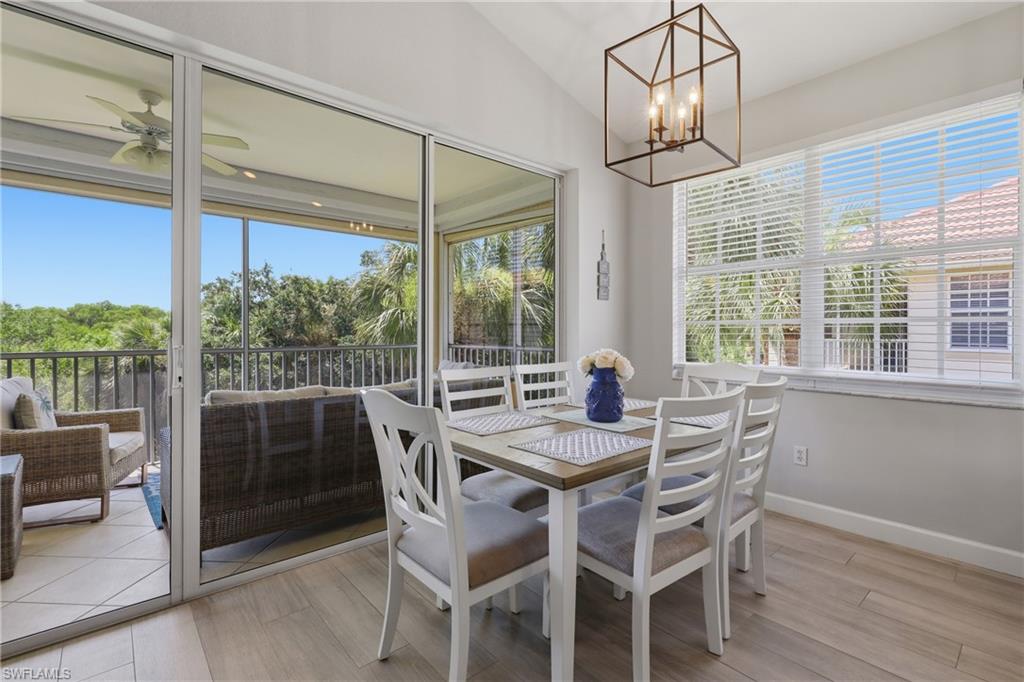 Dining area featuring vaulted ceilings, wood-finish flooring, and a contemporary caged chandelier