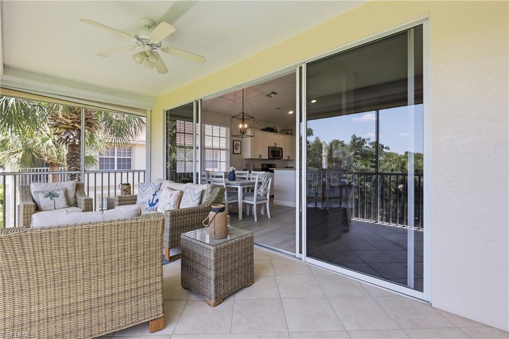 Screened outdoor patio featuring tile flooring and a ceiling fan