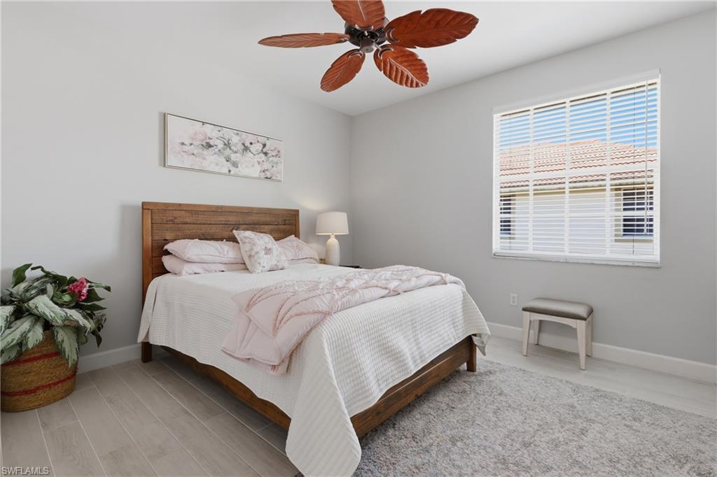 Bedroom featuring light wood-finish flooring and a ceiling fan with leaf-shaped blades