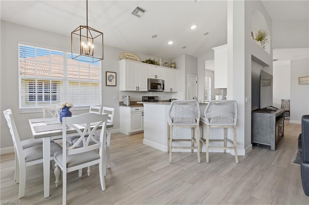 Open-concept kitchen and dining area featuring light wood-finish flooring