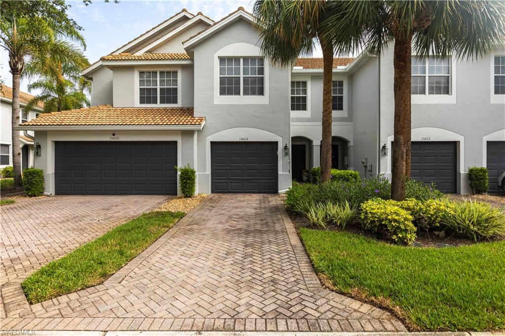 View of front of home with decorative driveway, stucco siding, a garage, and a tile roof