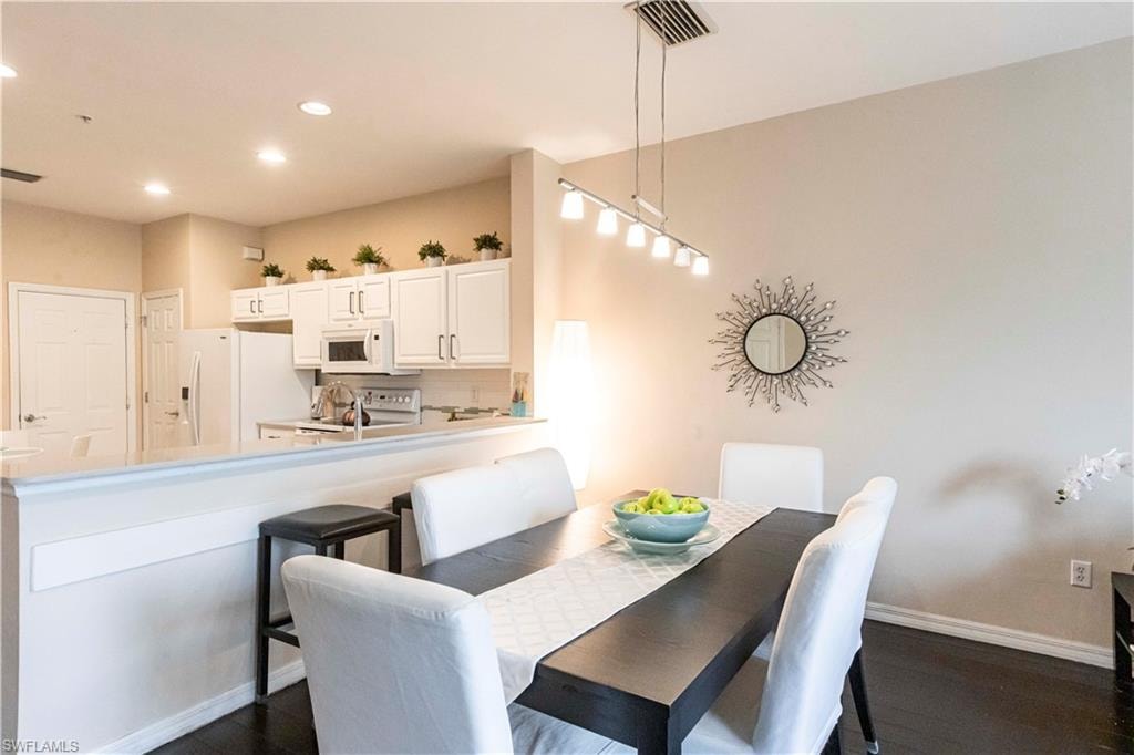Dining area featuring dark wood-style floors and recessed lighting
