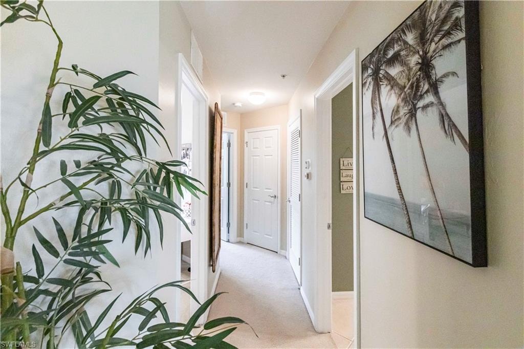 Hall featuring light carpet and baseboards