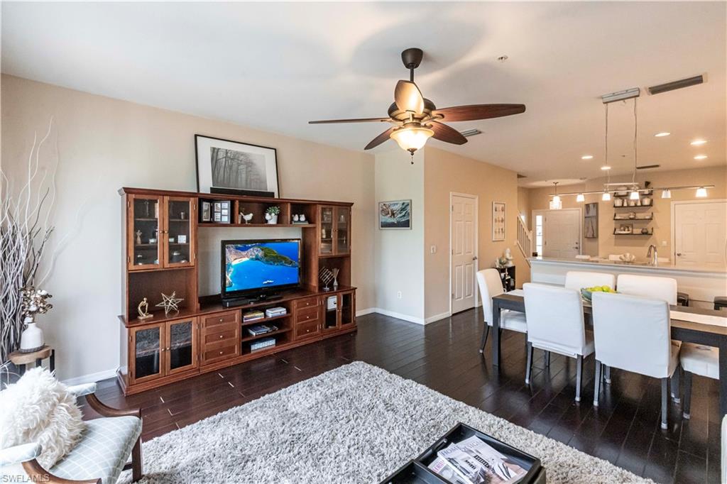 Living room featuring dark wood-type flooring, ceiling fan, and recessed lighting