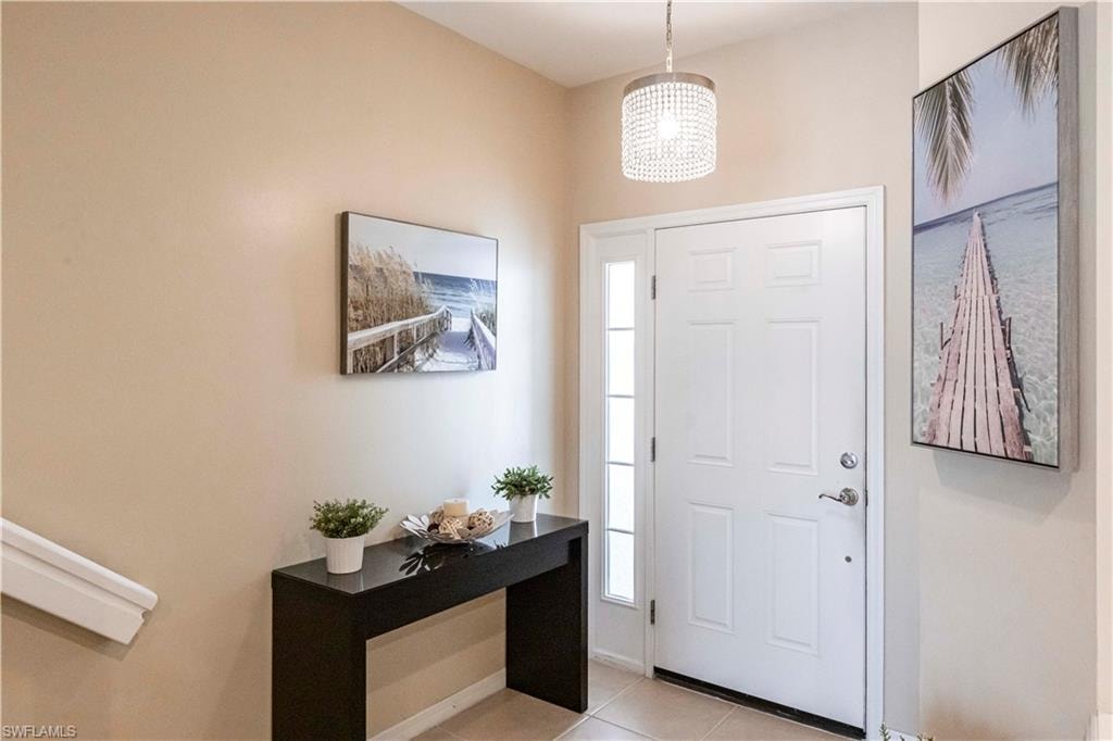 Foyer featuring light tile patterned floors and a chandelier