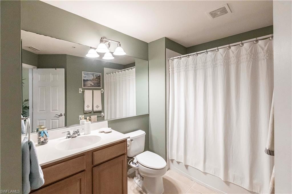 Bathroom with vanity, tile patterned flooring, and shower / bath combination with curtain