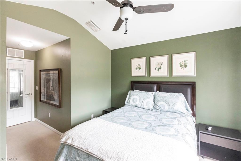 Carpeted bedroom with lofted ceiling and ceiling fan