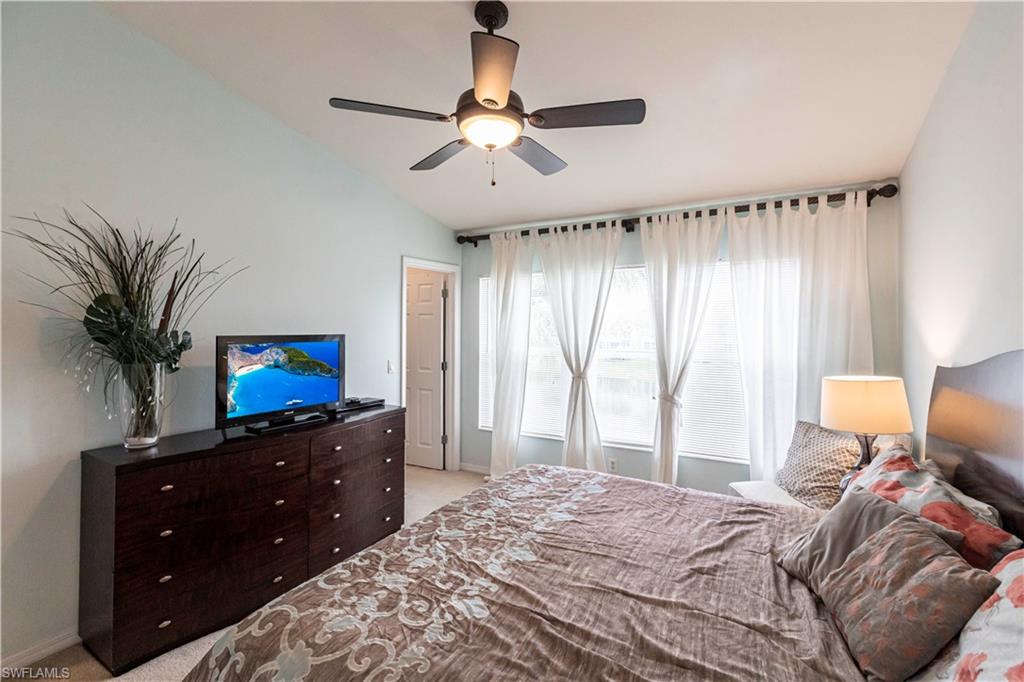 Bedroom featuring lofted ceiling, light carpet, and ceiling fan