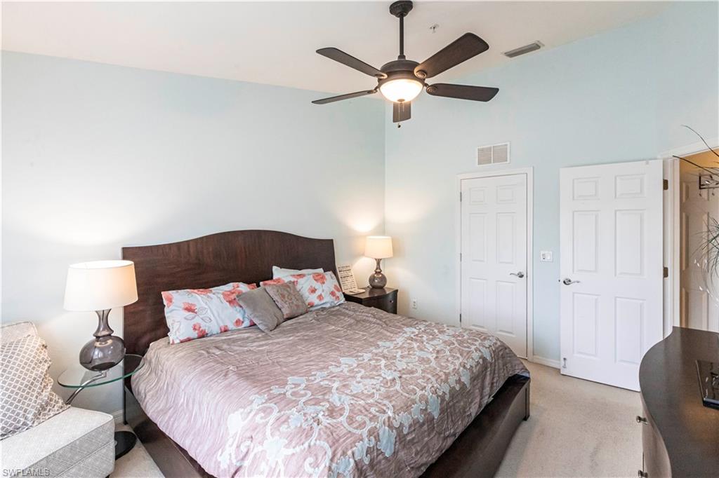 Bedroom featuring light colored carpet, high vaulted ceiling, and a ceiling fan