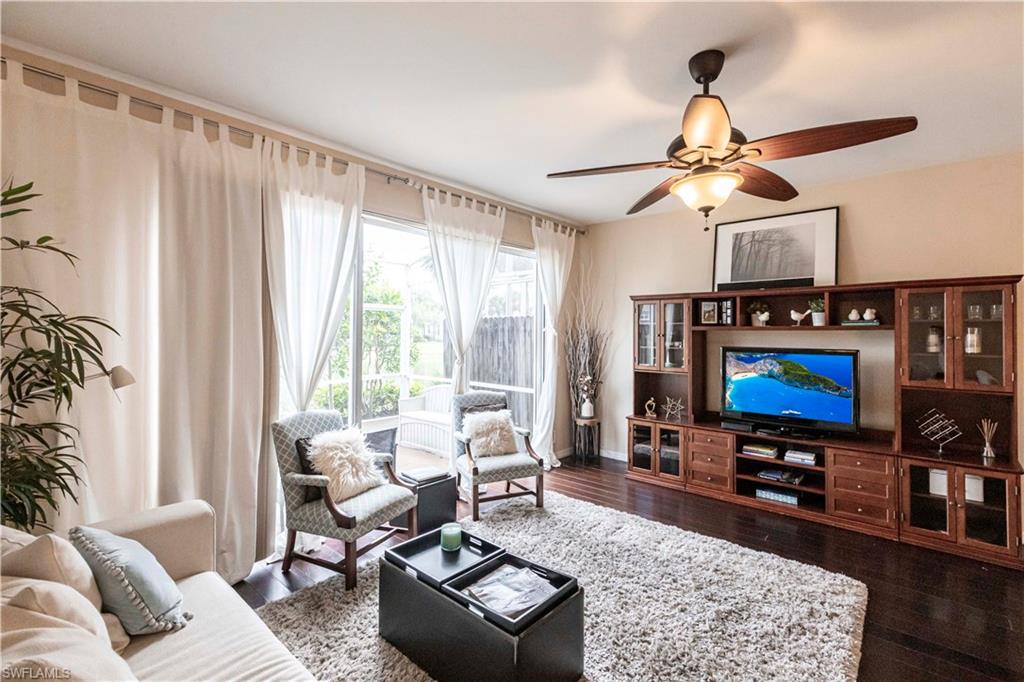 Living room with dark wood finished floors and a ceiling fan