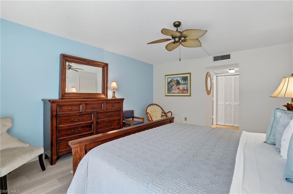 Spacious room featuring wood-finish flooring, a ceiling fan, and bi-fold closet doors