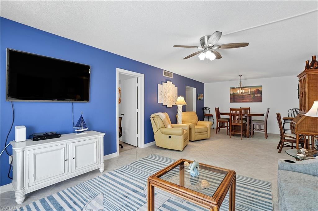 Open-concept living area featuring light tile flooring and a ceiling fan
