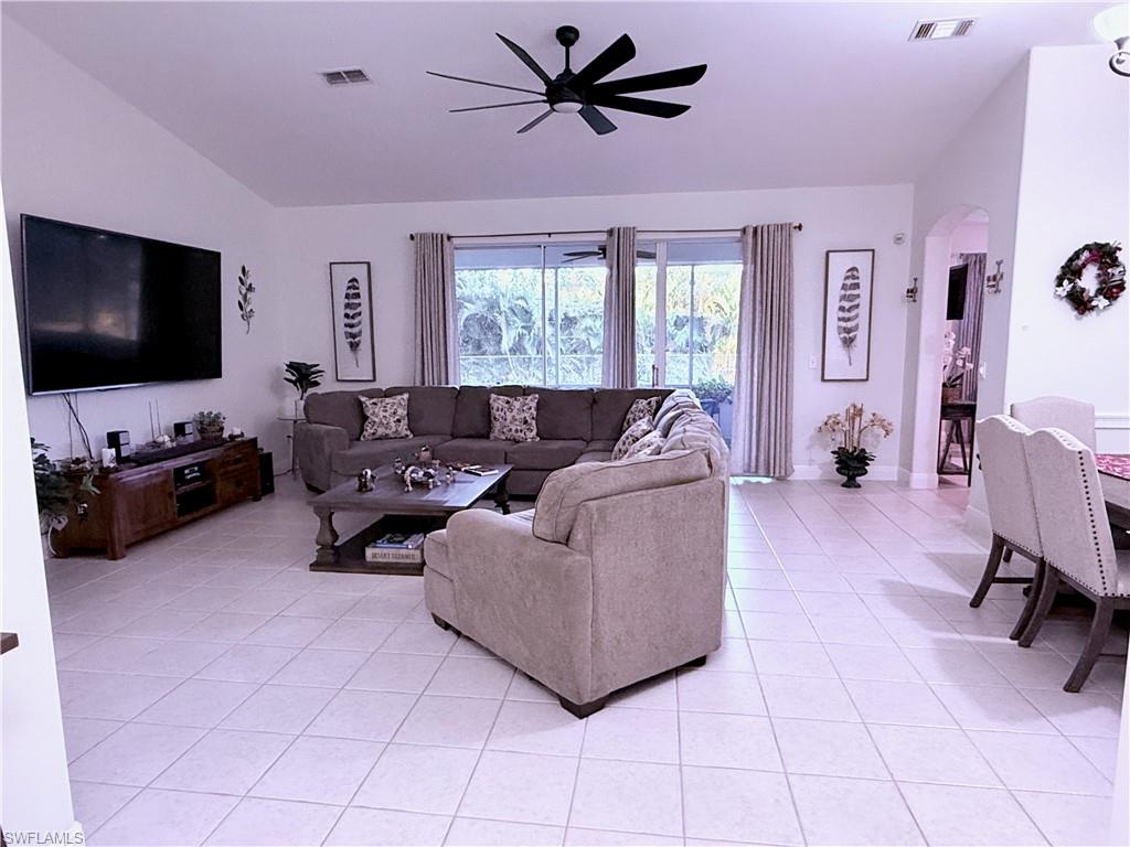 Vaulted ceilings, large sliding glass doors, ceiling fan, and tile flooring