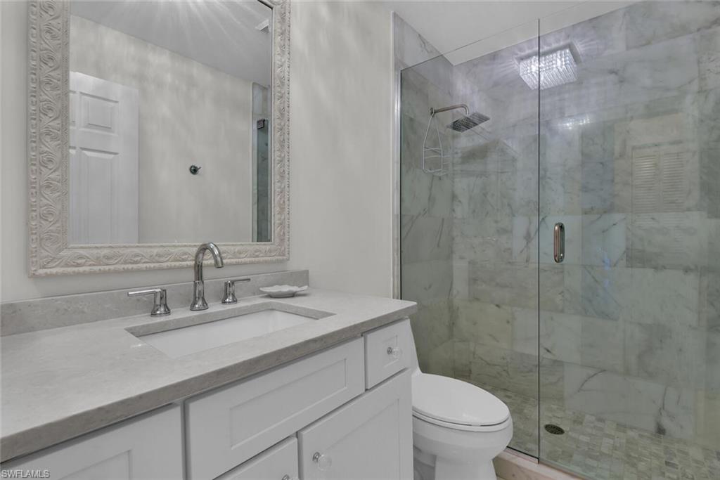Bathroom with a marble finish shower and vanity