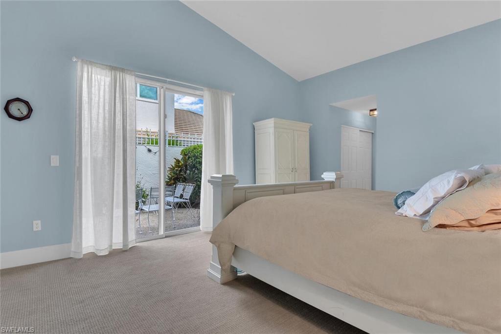 Carpeted bedroom featuring access to exterior and vaulted ceiling
