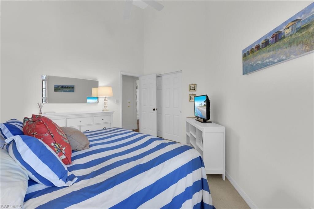 Bedroom with a towering ceiling, carpet flooring, a ceiling fan, and a closet
