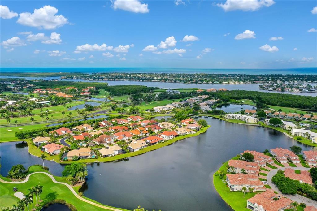 Aerial view of residential area with a nearby body of water and a golf club