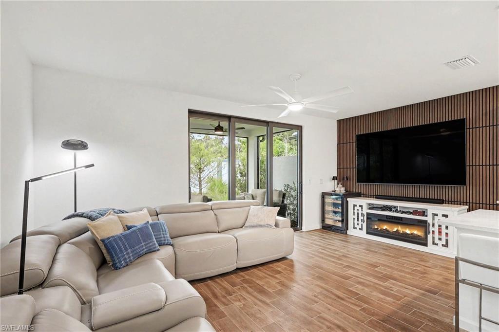 Open living area featuring wood-finish flooring, a contemporary ceiling fan, and sliding glass doors
