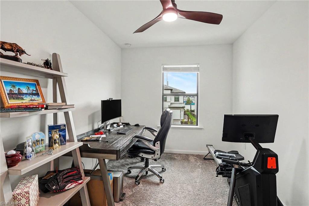 Carpeted room with a ceiling fan, a window, and white walls