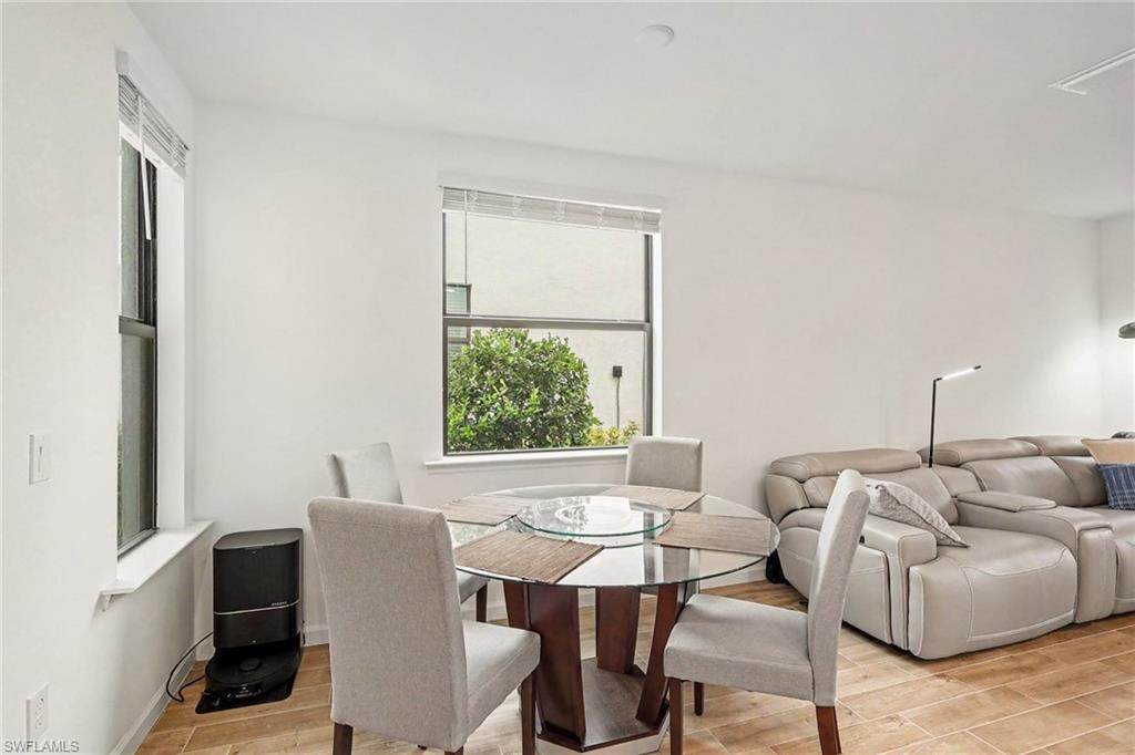 Bright interior space featuring light wood-finish flooring, white walls, and multiple windows