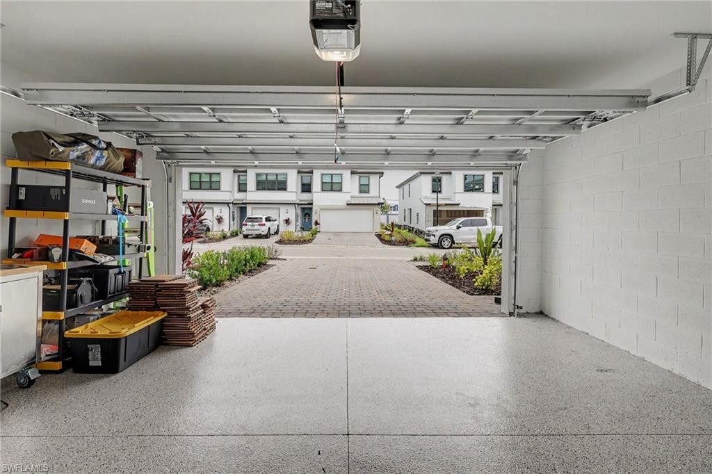 Attached garage featuring epoxy-coated flooring and concrete block walls