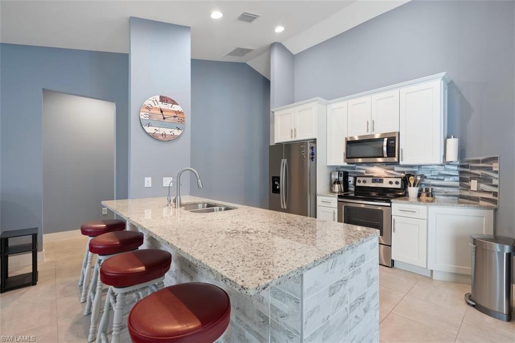 Kitchen featuring stainless steel appliances, granite counter tops and counter bar seating for 4