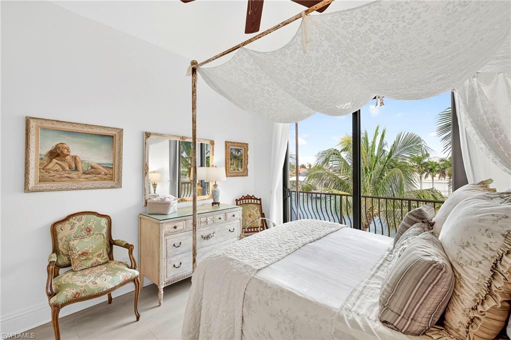Bedroom featuring access to outside, light wood-style flooring, a water view, and ceiling fan