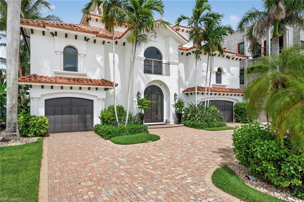 Mediterranean / spanish home featuring a tiled roof, an attached garage, stucco siding, and french doors