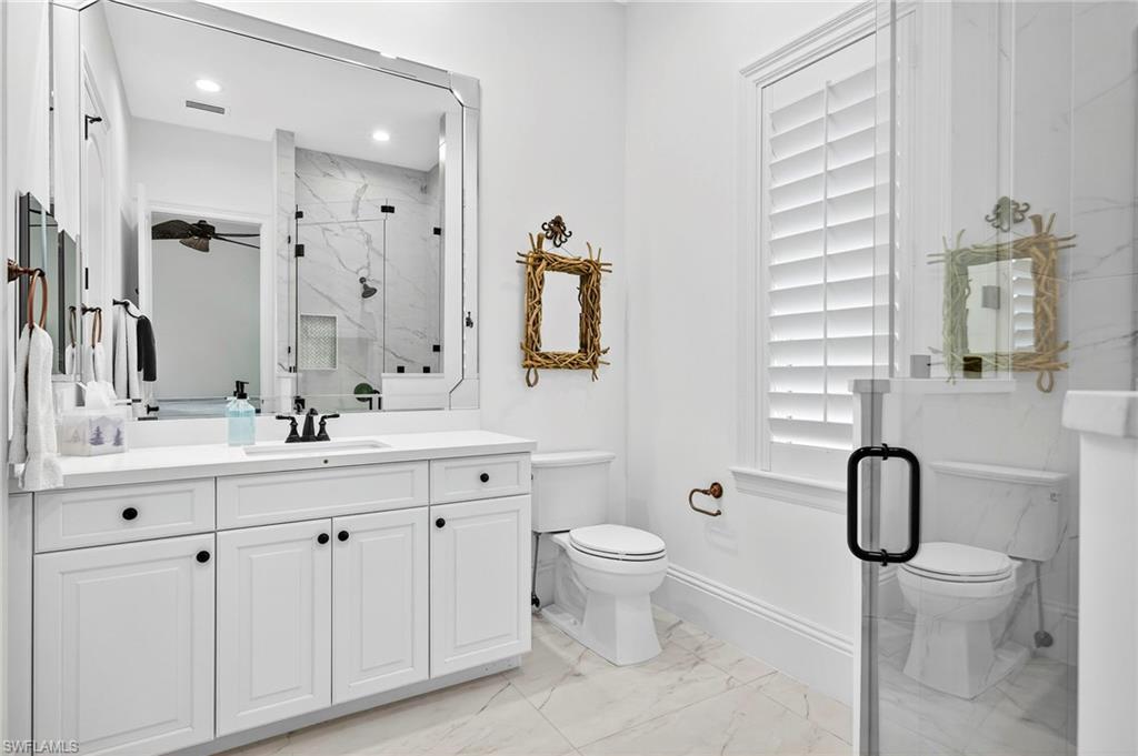 Full bathroom with a marble finish shower, vanity, and light marble finish floors