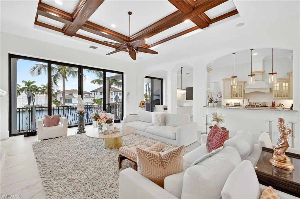 Living room with coffered ceiling, a water view, beam ceiling, a ceiling fan, and recessed lighting