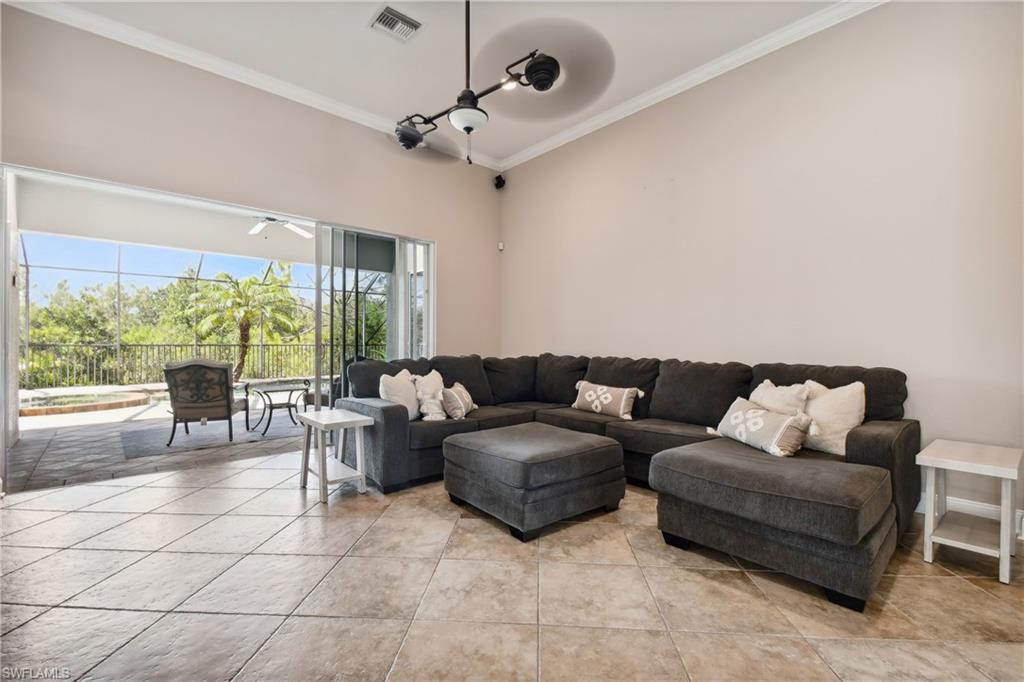 Living space featuring vaulted ceilings, crown molding, and large format diagonal tile flooring