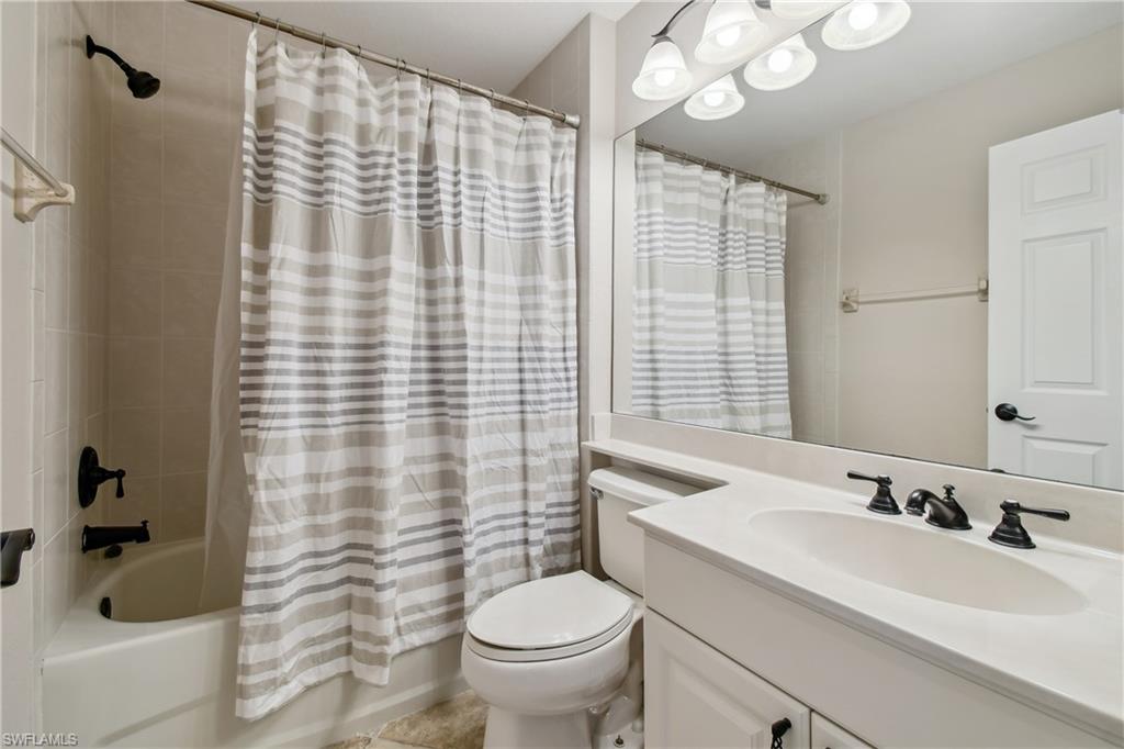 Bathroom featuring a single vanity with an integrated sink, dark bronze fixtures, and an elongated toilet