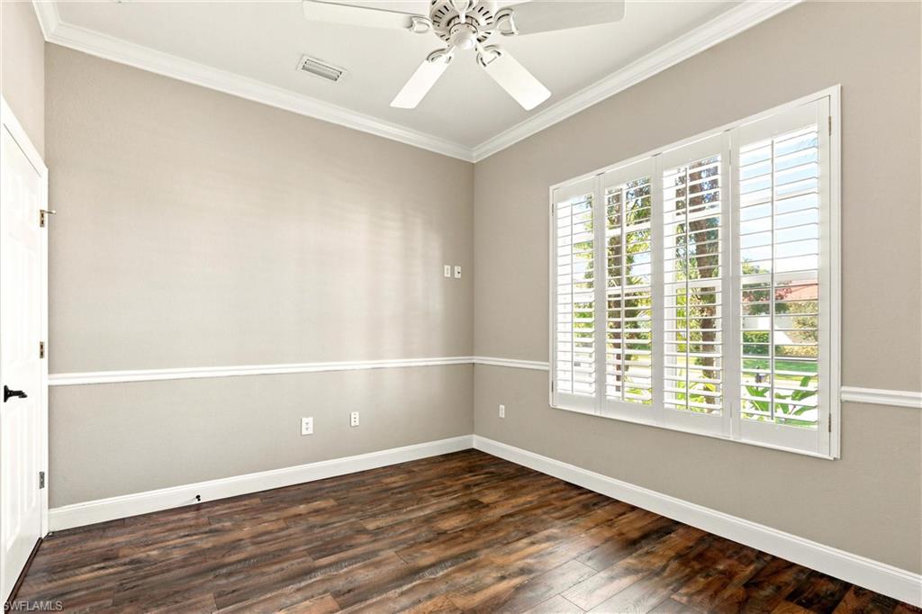 Room featuring wood-finish flooring, a ceiling fan, and crown molding