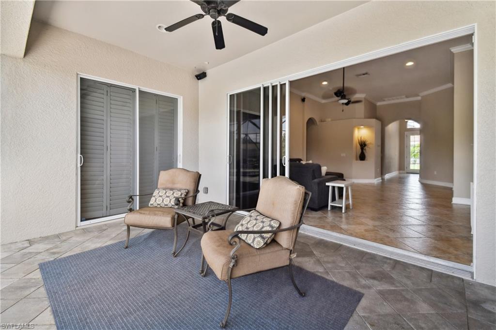 Covered patio featuring tiled flooring with a diamond pattern, a ceiling fan, and sliding glass doors opening to interior living spaces