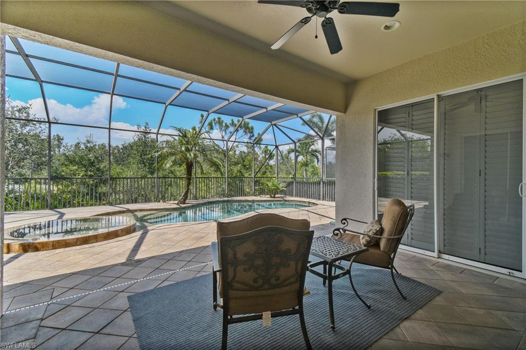 Screened lanai featuring a built-in swimming pool and spa