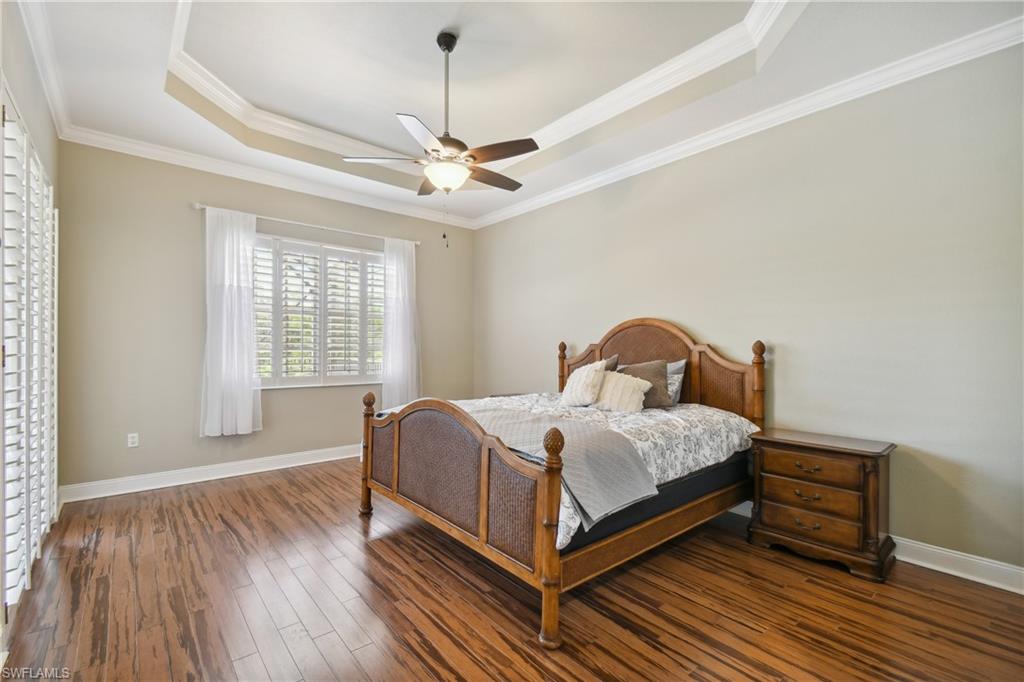 Spacious room featuring a tray ceiling with crown molding, and a ceiling fan