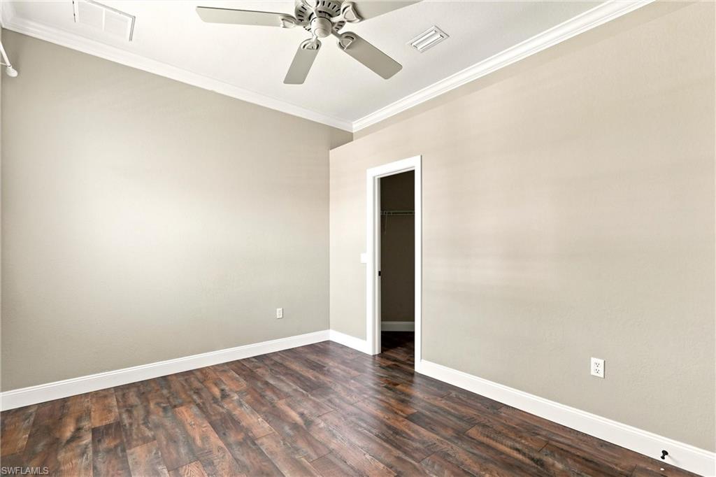 Interior space featuring wood-finish flooring, light-toned walls, and a ceiling fan