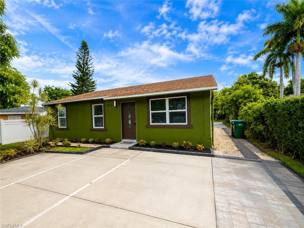 Green stucco exterior with white-framed windows and dark brown trim